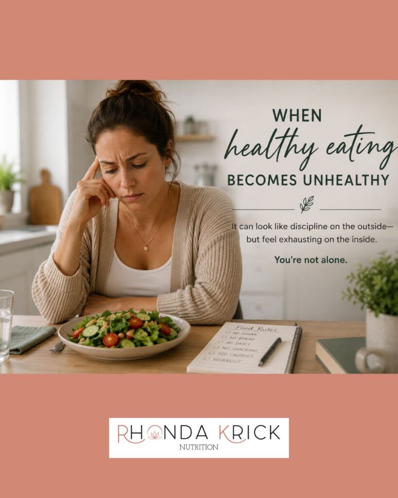 Woman sitting at a kitchen table looking stressed and deep in thought while eating a salad, with text reading “When Healthy Eating Becomes Unhealthy.” The image represents food anxiety, rigid food rules, and the emotional side of disordered eating.