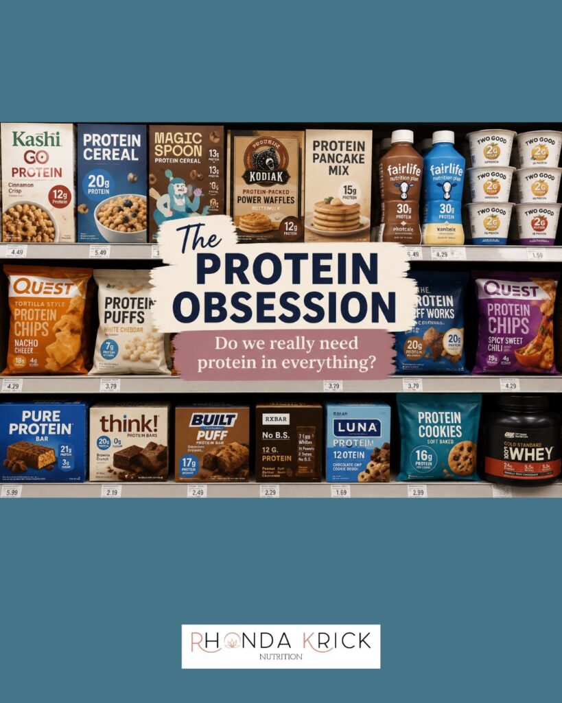 Grocery store shelf filled with high-protein foods including protein cereal, snacks, drinks, and desserts, illustrating the current protein obsession and trend of adding protein to everyday products.
